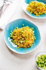 Cauliflower rice is a low calorie healthy substitute for grains of actual rice. Cauliflower rice seasoned with a mix of spices and tossed with olive oil lemon juice and garnished with scallions.