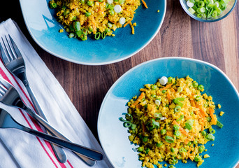 Cauliflower rice is a low calorie healthy substitute for grains of actual rice. Cauliflower rice seasoned with a mix of spices and tossed with olive oil lemon juice and garnished with scallions.