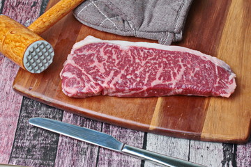 Ready raw fresh steak as wagyu beef  MS5+ with meat hammer on butcher served  for cooking .