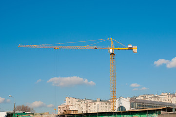 Crane and building under construction on blue sky background