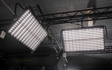 Large rectangular light panels for diffused and fill light in the Studio are suspended from metal...