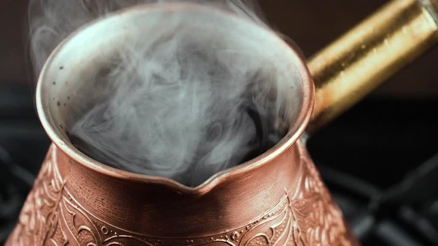 Hot black coffee in a coffee maker with a smoke 