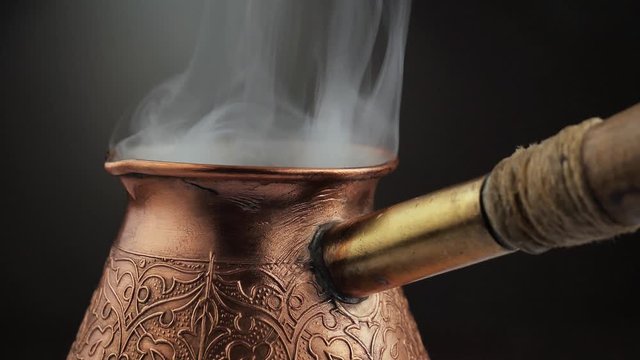 Hot black coffee in a coffee maker with a smoke 