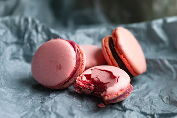 Bright pink delicious homemade traditional french macarons - elegant french dessert. Natural fruit and berry flavors, creamy stuffing. Front view, close up, macro. Grey background