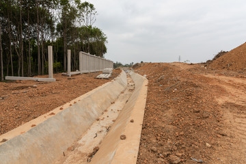 Fototapeta na wymiar Unfinished road concrete drainage ditch