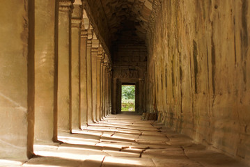 Columns at sunny South Gallery, Angkor Wat Temple, Cambodia. Sunbeams going through columns and shadows on floor