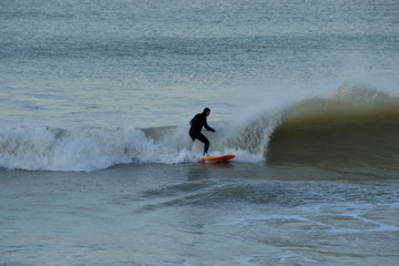 surfeur debout sur une planche, sport de glisse, vagues en  normandie, france