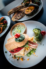 Loaded sandwich breakfast with bacon and vegetables with broccoli soup.