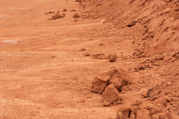 Flat red hard soil and dirt fragments closeup
