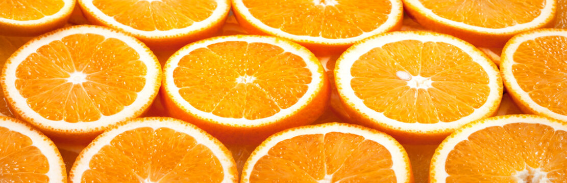 Background from fresh orange slices. Panorama. Banner.