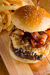 Bacon Cheese Burger. Classic American favorite cuisine. Hamburger with jalapenos , grilled mushrooms and melted cheeses and served with hand cut french fries. 
