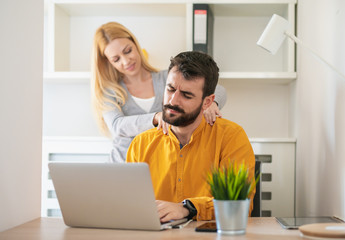 Man and woman at office, looking at laptop