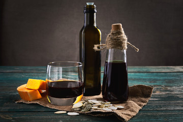 Pumpkin seed oil in a glass bottles on a wooden table