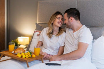 Obraz na płótnie Canvas Smiling couple watching TV at home
