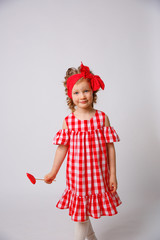 Funny smiling baby girl summer dress  on white background . Baby girl with a lip accessory on a stick.