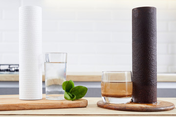 Water filter cartridge used , a glass of dirty water brown coloring and new pure filter with a...