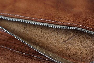 Close up details of a brown leather wallet.Zip and pocket