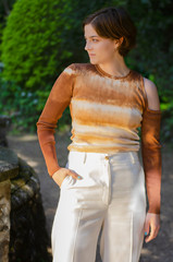 Fototapeta premium portrait of young woman with a tie-die shirt in a park