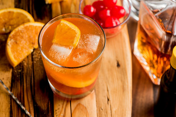 Old fashioned, Manhattan cocktail. Classic American drink favorite made w/ rye whiskey or bourbon & muddled maraschino cherries, oranges & sugar. Served on ice garnished w/ orange peel, cherry.