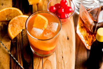 Old fashioned, Manhattan cocktail. Classic American drink favorite made w/ rye whiskey or bourbon & muddled maraschino cherries, oranges & sugar. Served on ice garnished w/ orange peel, cherry.