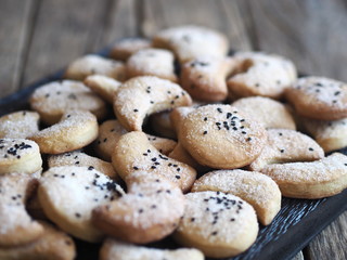 Homemade shortbread cookies sprinkled with sugar with black sesame seeds on a wooden rustic table. Place for text. Photo for the holiday, Shrovetide, Christmas, New Year, Easter.