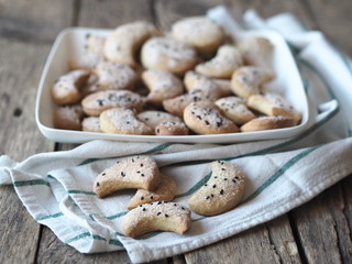 Homemade shortbread cookies sprinkled with sugar with black sesame seeds on a wooden rustic table. Place for text. Photo for the holiday, Shrovetide, Christmas, New Year, Easter.