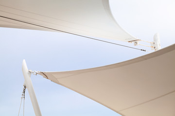 White awnings in sails shape under bright blue sky