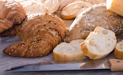 slices of wheaten bread and knife on wooden surface