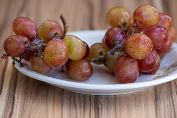 cacho de uvas vermelhas sobre mesa de madeira