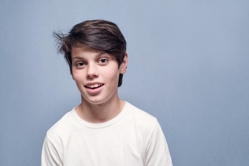 Portrait of a smiling teenager boy on a blue background