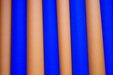 Bright rolls of blue and orange paper, close up. Background from paper