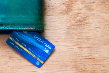 Top table view of mock up blue credit card insert between wallet with copy space