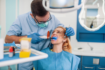 Dentist examining patient's teeth in clinic