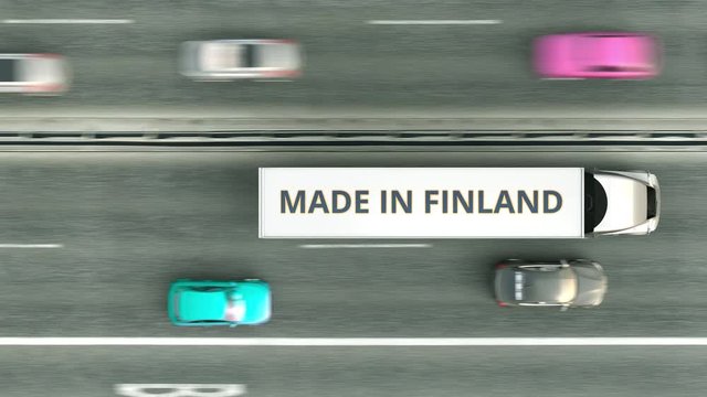 Aerial top down view of trailer trucks with MADE IN FINLAND text driving along the road. Finnish business related loopable 3D animation