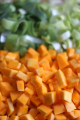Chopped leek and pumpkin on a wooden cutting board. Selective focus.