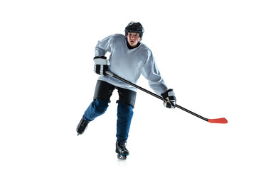 Running. Young male hockey player with the stick on ice court and white background. Sportsman wearing equipment and helmet practicing. Concept of sport, healthy lifestyle, motion, movement, action.