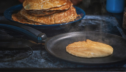 Making delicious pancake on iron frying pan. Home cooking