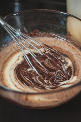 Dessert cream for lava cake cooking with hands in glass bowl