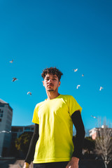 Portrait d'un jeune homme sportif devant un ciel bleu avec oiseaux en vol