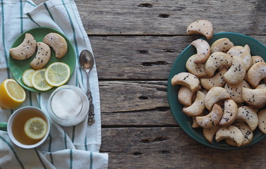 Homemade shortbread cookies sprinkled with sugar with black sesame seeds on a wooden rustic table. Tea party with cookies and lemon. Place for text. Photo for the holiday.