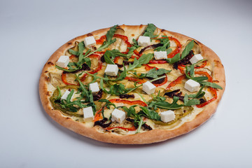 Pizza with feta arugula pepper and leafy tomatoes. Vegetarian pizza. Vegan pizza