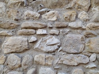 Old stone medieval wall background. Masonry walls in medieval Italian style. Close-up, background.	