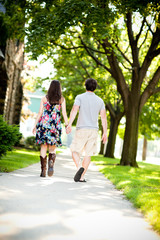 Obraz premium Young Couple Walking on Sidewalk in Neighborhood