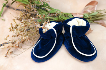 Baby booties and bouquet of dried flowers. Baby birthing background.
