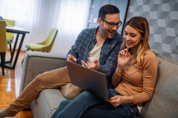 Smiling couple with laptop at home