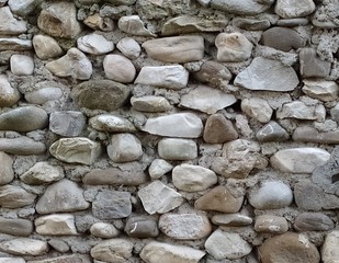 Background of stones. Old stone medieval wall background. Masonry walls in medieval Italian style. Close-up.