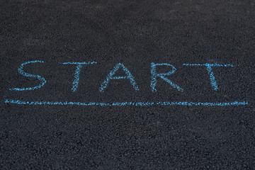 Inscription on the asphalt START. Notice on pavement. Lower head and read the important message.