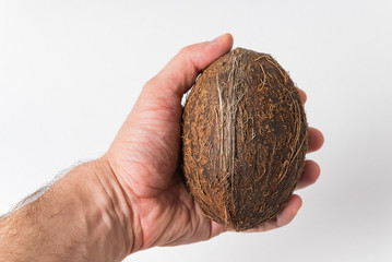Men's hand holds the coconut on white background. Tropical fruits. Close up
