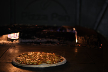 pizza in clay oven with firewood