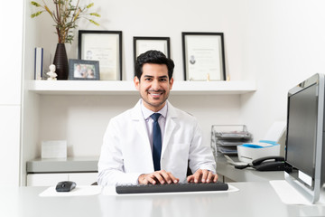 Smiling Latin Doctor Working In Clinic